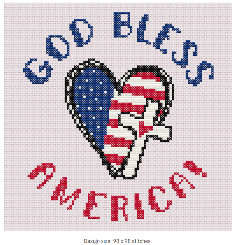 A cross-stitch pattern with the text 'GOD BLESS AMERICA' arranged in a heart shape with an American flag design within the heart, surrounded by a white border.