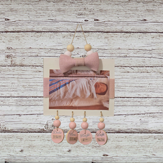 Decorative wall hanging with pink elements on a wooden background